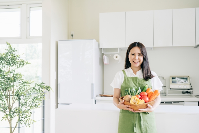 キッチンで野菜を持つ女性